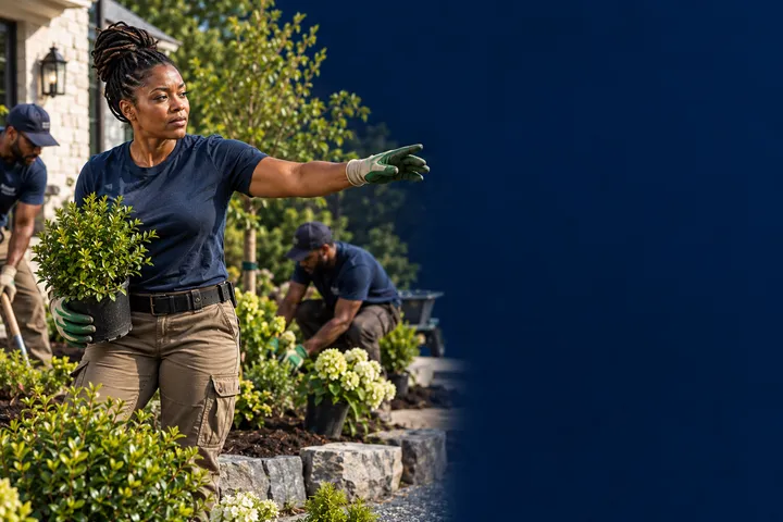 A woman leading a professional landscaping crew during a residential installation